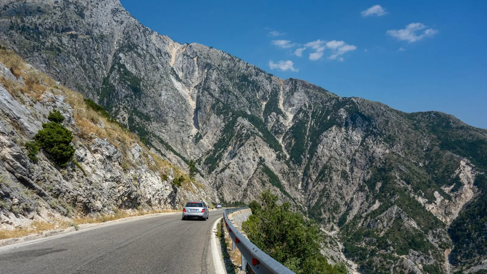 Car driving the Llogara Pass on an Albania road trip itinerary